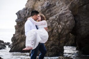 A couple kissing beside a rock formation